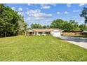 Beautiful single-Gathering home with a large front lawn and mature trees providing shade and curb appeal at 17605 Simmons Rd, Lutz, FL 33548