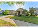 Beautiful home with a manicured lawn, lush shrubs, and a cozy porch, ideal for enjoying the outdoors at 20146 Heritage Point Dr, Tampa, FL 33647
