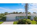 Charming home featuring brick driveway, manicured lawn and lush tropical landscaping at 2540 S Shore Se Dr, St Petersburg, FL 33705