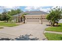 A large driveway leading to the three-car garage of a single-story home with a well-maintained lawn at 3009 Sheehan Dr, Land O Lakes, FL 34638