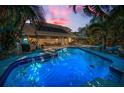 Backyard pool with a sun deck, solar panels, manicured lawn, and outdoor seating at 508 N Mayo St, Crystal Beach, FL 34681