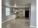 Bright kitchen with white cabinets, tile flooring, and modern appliances at 5151 Janice Ln, Holiday, FL 34690