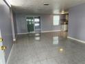 Open-concept living room with tile flooring and sliding glass doors at 5151 Janice Ln, Holiday, FL 34690