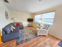 Inviting living room with a comfortable couch, bright rug, and large windows that fill the space with natural light at 5935 30Th S Ave # 308, Gulfport, FL 33707