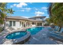 Beautiful backyard featuring a sparkling pool, spa, and lounging area surrounded by tropical landscaping at 597 Bay St, Palm Harbor, FL 34683