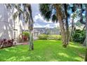 Expansive, well-manicured backyard featuring a screened-in pool and tropical landscaping at 6112 Ibispark Dr, Lithia, FL 33547