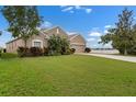 Lovely one-story home with a manicured lawn, mature landscaping, and a glimpse of the lake in the background at 626 15Th Nw Ave, Ruskin, FL 33570