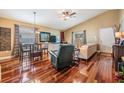 Living room area with hardwood floors, a ceiling fan, and a view of the dining area at 7508 S Mascotte St, Tampa, FL 33616