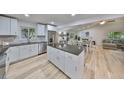 Modern kitchen with white cabinets, granite countertops, and stainless steel appliances at 940 Woodland Dr, Palm Harbor, FL 34683
