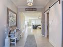 Warm foyer with tile flooring, decorative bench, and views into the living spaces at 10978 Laxer Cay Loop, San Antonio, FL 33576