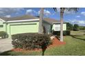 Single-story home with a well-maintained lawn, mature bushes, and a two-car garage at 11468 Captiva Kay Dr, Riverview, FL 33569
