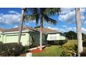 Charming single-story home with a well-manicured lawn and lush landscaping, including palm trees at 11468 Captiva Kay Dr, Riverview, FL 33569