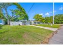 Lovely single-story home with a well-manicured lawn and bright green landscaping at 1290 Bertland Way, Clearwater, FL 33755
