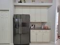Modern kitchen with stainless steel refrigerator and white cabinets at 16106 Bridgedale Dr, Lithia, FL 33547