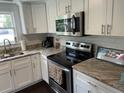 Well-lit kitchen with white cabinets, stainless appliances, and granite countertops at 1626 27Th N Ave, St Petersburg, FL 33713