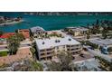 Aerial shot of a condominium complex near the water, featuring balconies and ample parking at 1700 Pass A Grille Way # 9, St Pete Beach, FL 33706