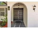 Inviting entryway with double doors, stone flooring, and decorative sconce lighting at 1905 Oro Ct, Clearwater, FL 33764