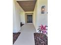 Inviting home entrance with stylish accent lighting, lush landscaping, and a covered entryway at 2869 Thistle N Ct, Palm Harbor, FL 34684