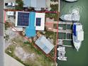 Aerial view of waterfront property with solar panels, boat dock, and canal access at 301 Boca Ciega Dr, Madeira Beach, FL 33708