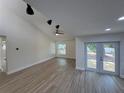 Bright and airy living room showcasing new floors, vaulted ceilings, and sliding door access to the yard at 3924 Orchard Hill Cir, Palm Harbor, FL 34684