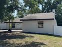 Side view of a well-maintained single-Gathering home, partially fenced in, with healthy, green lawn at 3924 Orchard Hill Cir, Palm Harbor, FL 34684
