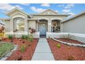 Beautiful home entrance featuring a garden, tidy mulch, and charming light fixtures along the walkway at 4010 Lithia Ridge Blvd, Valrico, FL 33596