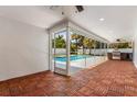 View of the pool and wooden patio with an outdoor kitchen area and sliding glass doors for indoor/outdoor entertaining at 429 88Th Ave, St Pete Beach, FL 33706