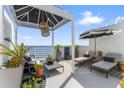 Inviting condo balcony with lounge chairs, modern decor, sun shade, and beautiful waterfront views at 4950 Bayshore Blvd # 27, Tampa, FL 33611