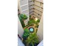 View looking down into the courtyard, featuring lush greenery, walkways, and a central fountain at 500 N Osceola Ave # 808, Clearwater, FL 33755