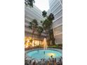 Outdoor common area with a circular fountain surrounded by tropical landscaping and tall condo buildings at 500 N Osceola Ave # 808, Clearwater, FL 33755