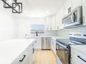 Bright kitchen features white cabinets, stainless steel appliances, and a modern black faucet at 5290 101St Ave, Pinellas Park, FL 33782
