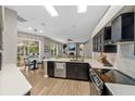 Modern kitchen featuring stainless steel appliances, quartz countertops, and a view to the living area at 5605 Glencrest Blvd, Tampa, FL 33625