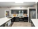 This kitchen features stainless steel appliances, black cabinets and contrasting quartz countertops and backsplash at 5605 Glencrest Blvd, Tampa, FL 33625