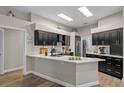 Modern kitchen featuring dark cabinetry, a center island, white countertops, and stainless steel appliances at 5605 Glencrest Blvd, Tampa, FL 33625