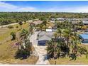 A serene neighborhood showcases lush greenery and single-Gathering homes with tropical trees at 595 Denburn Ct, Englewood, FL 34223