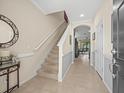 Bright foyer with tile flooring, a staircase, an arched doorway, and a modern entry door at 602 Cabernet Way, Oldsmar, FL 34677