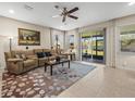 Bright living room with neutral tones, a large window, and a sliding glass door leading to the patio at 602 Cabernet Way, Oldsmar, FL 34677