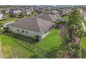 Aerial view of a fenced backyard featuring a well-maintained lawn, mature trees, and a screened patio at 6326 Waves End Pl, Apollo Beach, FL 33572
