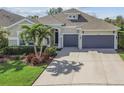 Beautiful home with a manicured lawn, landscaped garden, and a spacious driveway leading to a two-car garage at 6326 Waves End Pl, Apollo Beach, FL 33572