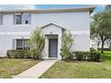 Exterior view of a two-story townhome with gray shutters and a well-maintained lawn at 7303 E Bank Dr, Tampa, FL 33617