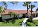 Exterior of home featuring a tile roof, well-manicured lawn, and walkway at 773 Snug Is, Clearwater Beach, FL 33767