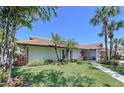 Exterior view of home with lush landscaping, walkway, and tile roof at 773 Snug Is, Clearwater Beach, FL 33767