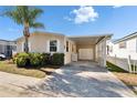 Inviting single-story home featuring a covered parking area and lush landscaping, perfect for relaxed living at 8528 Fantasia Park Way, Riverview, FL 33578