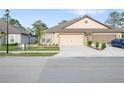 Lovely single-story home featuring an attached two-car garage and a well-maintained lawn at 8975 Southern Charm Cir, Brooksville, FL 34613