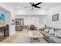 Open-concept living area with a modern kitchen, a gray sofa, light wood floors, and a ceiling fan at 9481 Highland Oak Dr # 514, Tampa, FL 33647