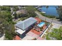 This aerial showcases a home with pool, shaded carport, brick driveway, and mature landscaping at 101 Pampas Ave, Tarpon Springs, FL 34689