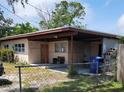 Single story house with covered carport, fenced yard, and an exterior storage area at 10106 66Th Ave, Seminole, FL 33772