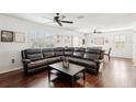Spacious living room with hardwood floors, fan, and leather sectional at 10230 Geese Trail Cir, Sun City Center, FL 33573