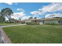 Beautiful home with a large front lawn, well-manicured landscaping, and bright blue skies at 1137 86Th N Ave, St Petersburg, FL 33702