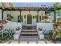 Welcoming front porch with hanging flower baskets, unique tiled steps, and a covered entry at 1175 Jackson Rd, Clearwater, FL 33755